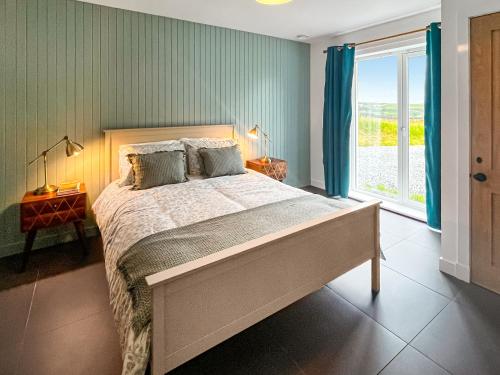 a bedroom with a large bed and a window at Taigh Mullach Dearg in Portree