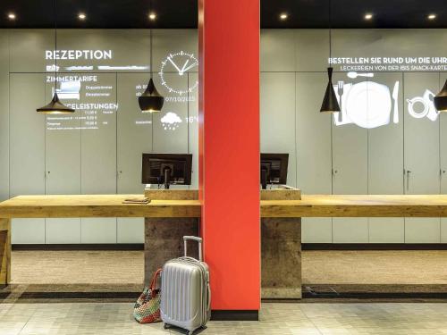 a suitcase is sitting next to a counter in a store at Ibis Berlin Hauptbahnhof in Berlin