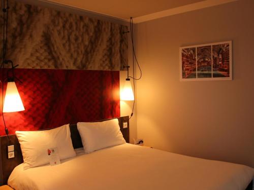 a hotel room with a bed with two white pillows at Ibis Berlin Hauptbahnhof in Berlin