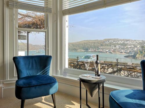 a room with a blue chair and a table and a window at Seascape - St Catherine's Court in Fowey