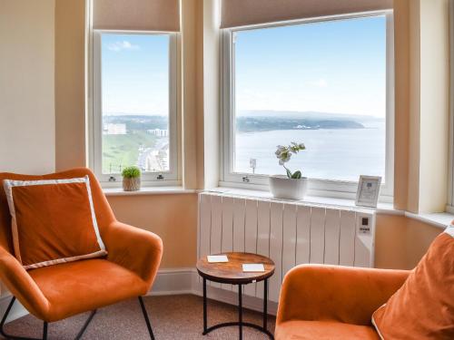 a living room with two chairs and two windows at Denelea Studio 2 - Uk49953 in Scarborough