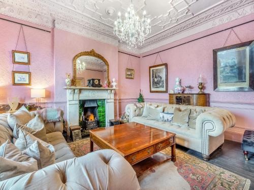 a living room filled with furniture and a fireplace at Greystonedale Mansion Holiday Retreat in Haltwhistle