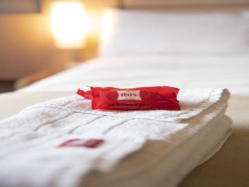 a red packet on top of a bed at ibis Pilar in Pilar