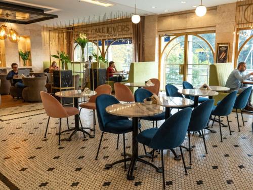 a restaurant with tables and chairs and people in the background at ibis Pilar in Pilar