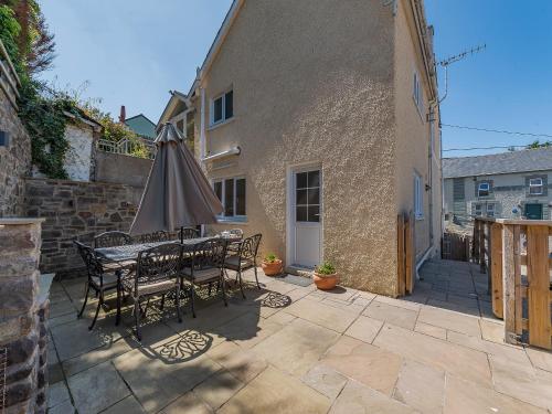 a patio with an umbrella and a table and chairs at Spring Gardens in New Quay