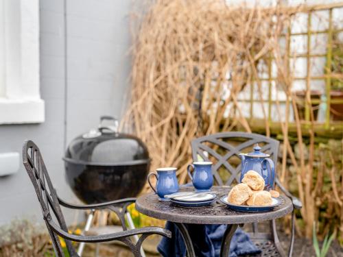 a small table with blue cups and biscuits on it at Number Seven in High Bentham