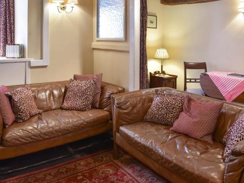 a living room with two brown leather couches at Church Street in Ambleside
