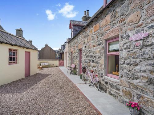 a stone building with two bikes parked outside of it at Coast Away in Fraserburgh