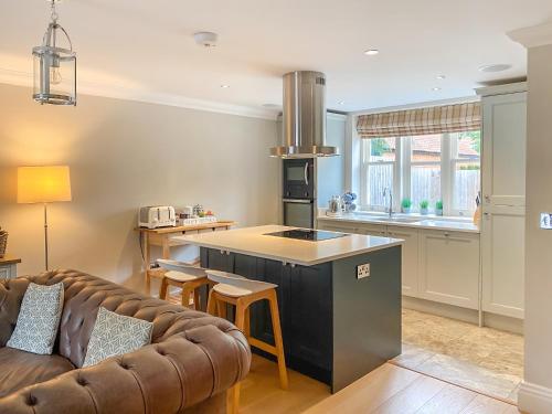 a kitchen and a living room with a couch at Rye Cottage in Helmsley