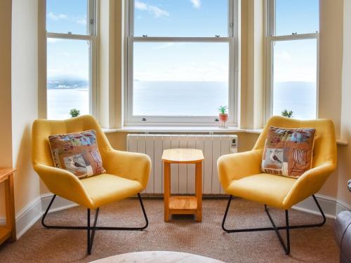 two chairs and a table in a room with windows at Denelea - Uk49954 in Scarborough