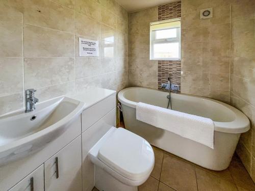 a bathroom with a tub and a toilet and a sink at Ivy - Uk50105 in Brigg