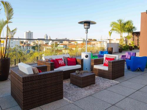 a patio with couches and chairs on a roof at ibis Jundiai Shopping in Jundiaí