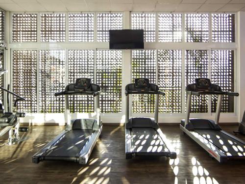 a gym with three treadmills in front of a large window at ibis Jundiai Shopping in Jundiaí