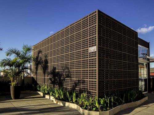 a tall brick building with a person projected on it at ibis Jundiai Shopping in Jundiaí