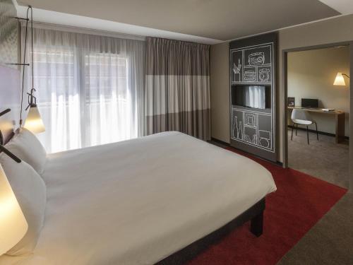 a hotel room with a large bed and a desk at ibis Lille Centre Grand Palais in Lille