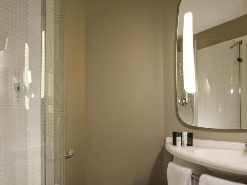 a bathroom with a sink and a shower with a mirror at ibis Lille Centre Grand Palais in Lille