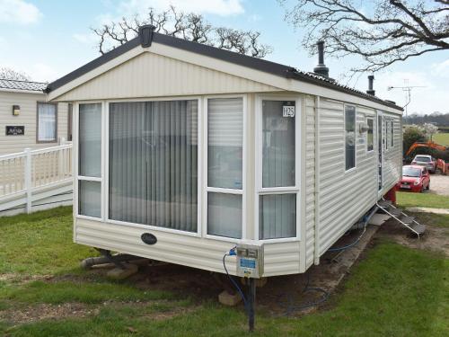 a white tiny house parked in a yard at Flip-Flop Lodge in Sandown