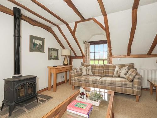 a living room with a couch and a stove at The Hayloft in Milnathort