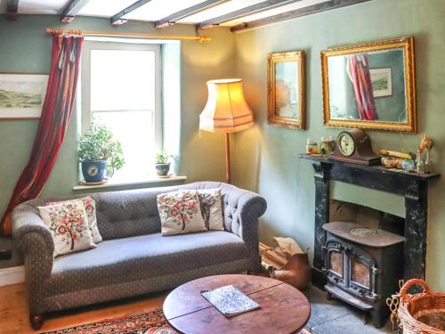 a living room with a couch and a fireplace at Farm House - Uk50262 in Llandeilo