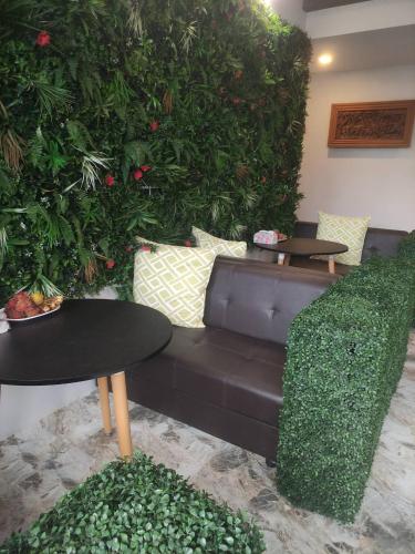 a living room with a couch and tables and plants at อยู่สบายวิลล่า ยโสธร in Yasothon