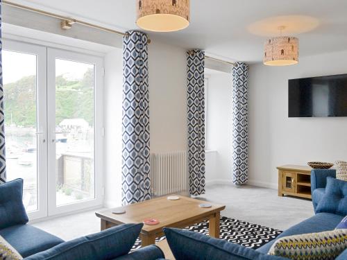 a living room with blue chairs and a table at Blue Beach House in Ilfracombe