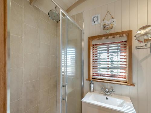 a bathroom with a shower and a sink at Bonnie's Shepherd Hut - Uk50228 in Nottingham