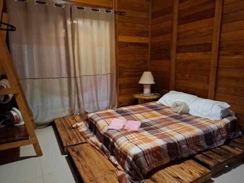 a bedroom with a bed with a teddy bear on it at Cabana de madeira entre as árvores in Piedade