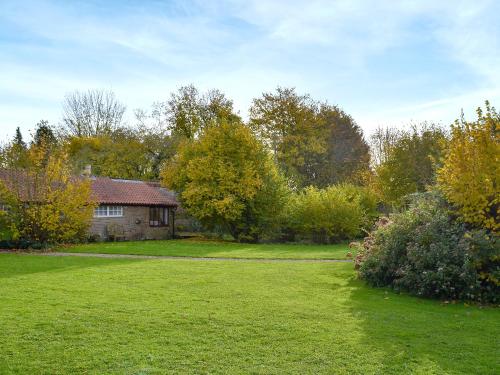 a house in a yard with a green lawn at Gamekeeper's Cottage in Staple