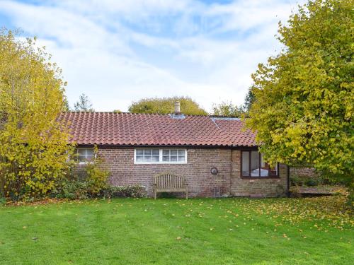 a brick house with a green lawn in front of it at Gamekeeper's Cottage in Staple