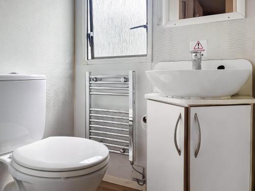 a bathroom with a white toilet and a sink at Swaledale 5 in Tosside