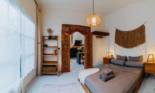 a bedroom with a large bed and a mirror at NEW Cozy, Smart, Renovated Flat Western Standard in Ubud