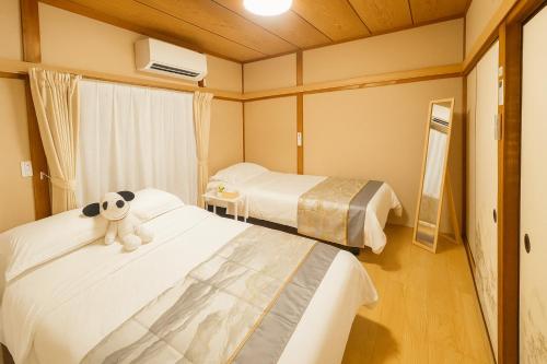 a hotel room with two beds with a stuffed animal on them at Mie's House Skytree 美英軒 in Tokyo