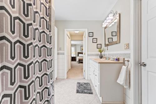 a bathroom with a geometric patterned shower curtain at Ohio City 4 Bed 3 TV Free Parking Mins to DT in Cleveland