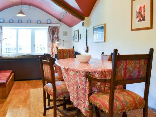 comedor con mesa con sillas y cocina en Birkerthwaite Cottage-W41479, en Eskdale