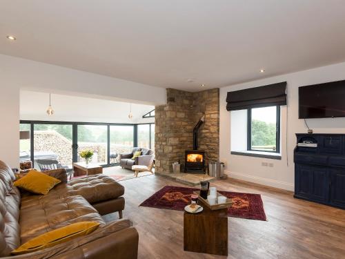 ein Wohnzimmer mit Couch und Kamin in der Unterkunft Moorgate Cottage - Ukc3380 in Kelbrook