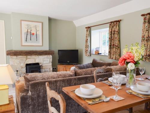 ein Wohnzimmer mit Sofa und Tisch in der Unterkunft Cowbeech Farm Cottage in Herstmonceux