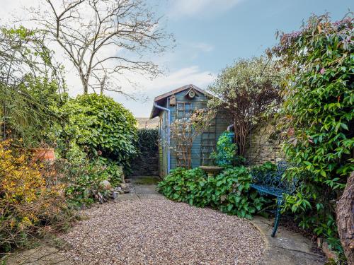 un jardín con un banco frente a un edificio en September Cottage, en Lechlade
