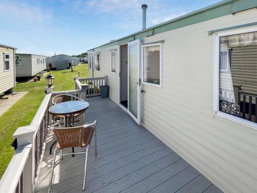 a deck with chairs and a table on a trailer at The Hunters Haven in Skegness