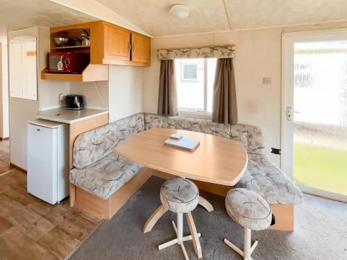 a caravan dining room and kitchen with a table and a couch at The Hunters Haven in Skegness