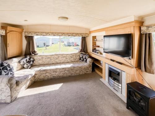 a living room with a couch and a tv in a caravan at The Hunters Haven in Skegness