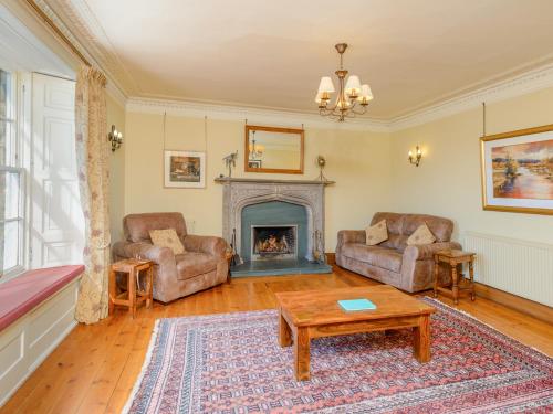 un soggiorno con due sedie e un camino di Winton Cottage - Uk50380 a Pencaitland