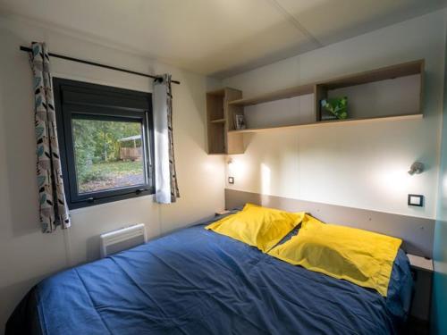 a bedroom with a bed with a yellow and blue blanket at Mobil home 32m² avec terrasse, 3 chambres pour 6 personnes - API-1-52-713 in Barbey-Séroux