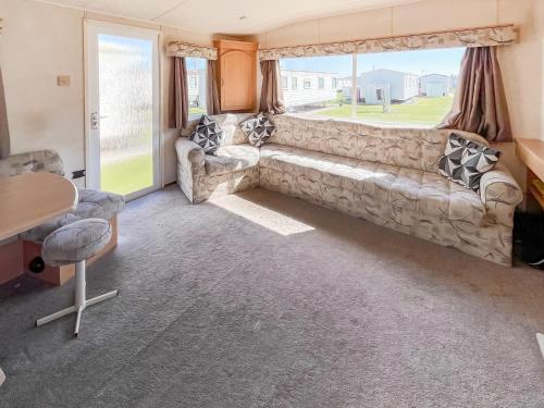 a living room with a couch and a large window at The Hunters Haven in Skegness
