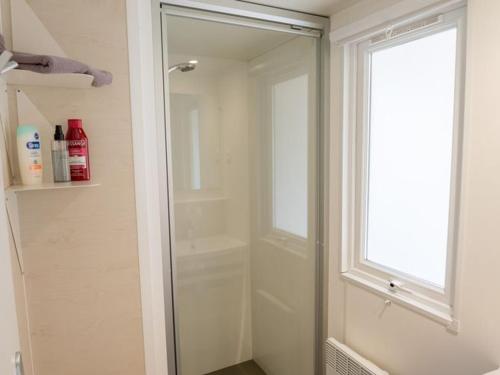 een badkamer met een douche met een glazen deur bij Mobil home avec terrasse au camping à Granges-Aumontzey - API-1-52-299 in Barbey-Séroux