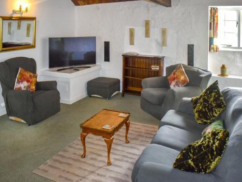 ein Wohnzimmer mit Sofas und einem Flachbildfernseher in der Unterkunft Cider Cottage - Uk50076 in Sidmouth