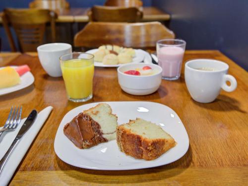 a table with a plate of cake and coffee and drinks at ibis Rio de Janeiro Nova America in Rio de Janeiro