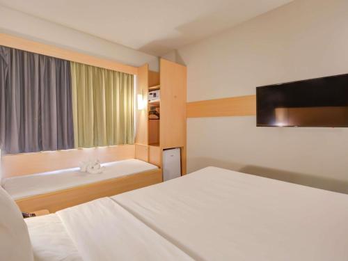 a hotel room with a bed and a bath tub at ibis Rio de Janeiro Nova America in Rio de Janeiro