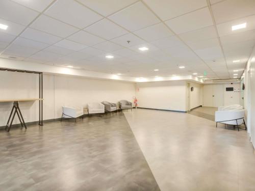 an empty room with white chairs and a white board at ibis Rio de Janeiro Nova America in Rio de Janeiro