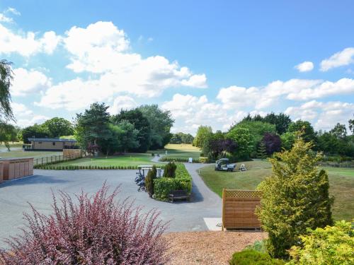 a view of a park with a bench and trees at Fairways Retreat 3 - Uk50248 in Cottingham