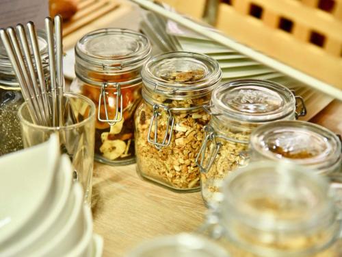 a table topped with jars of food and utensils at Mercure Cholet Centre in Cholet